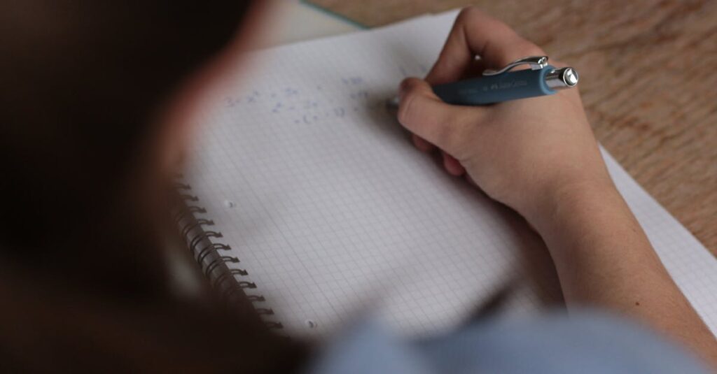 A student writes mathematical notes in a notebook using a pen, focus on studying.