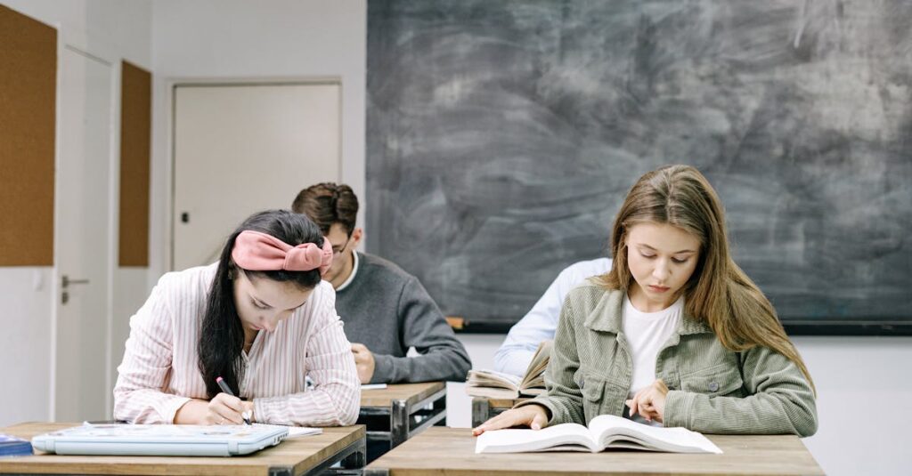 Young students studying in a classroom, focused on reading and writing assignments.
