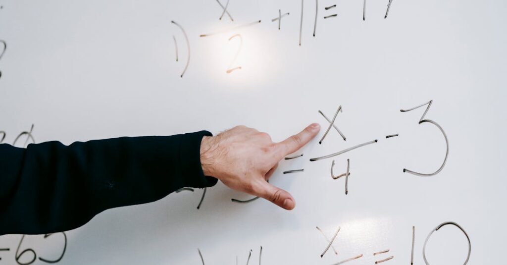 Close-up of an instructor's hand solving math equations on a whiteboard during a lesson.